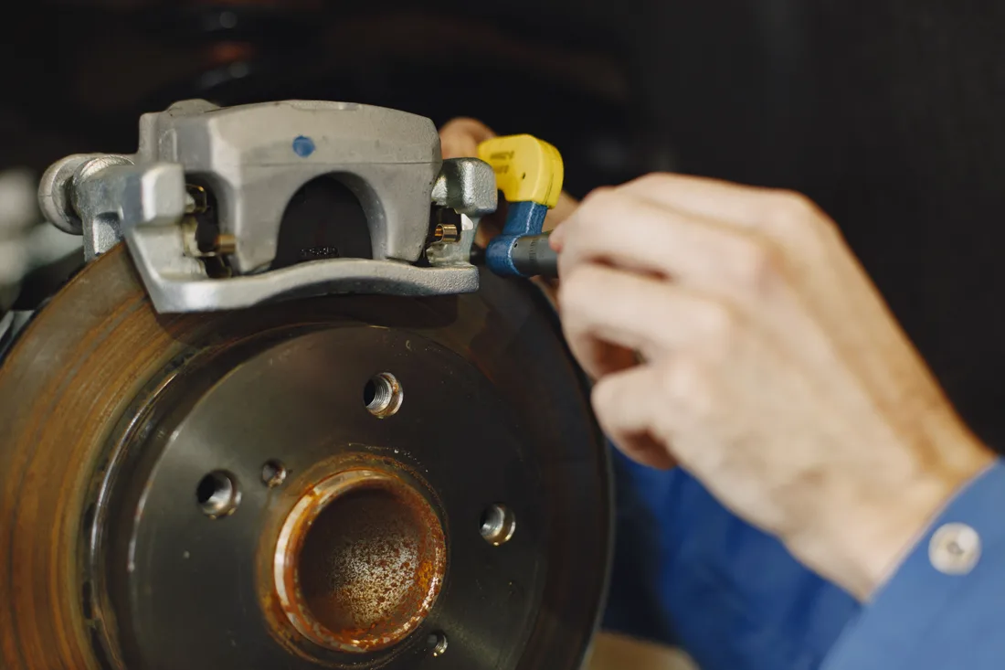 Mechanic working on a brake caliper and rotor