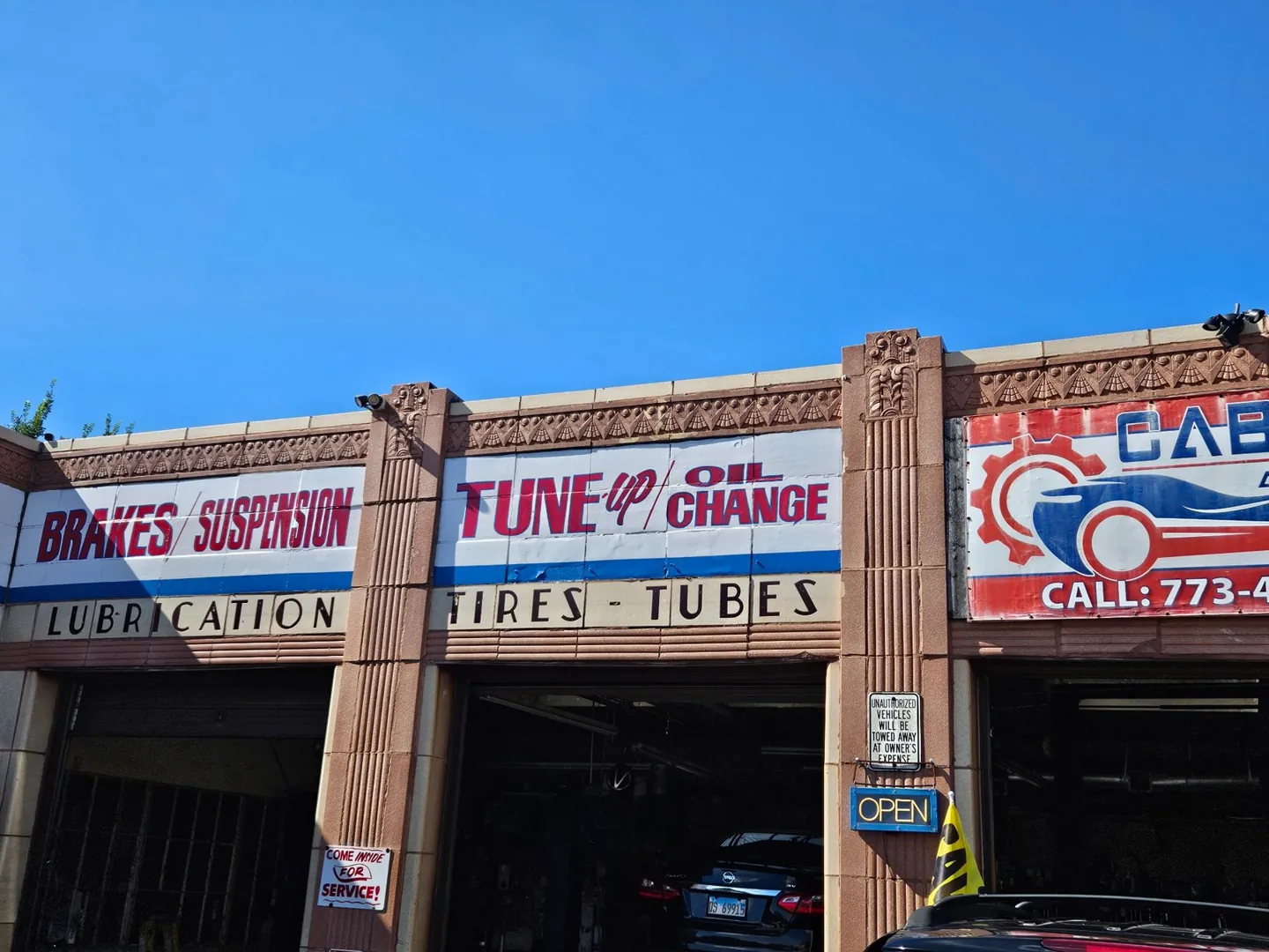 Cabrera service bays with signs for brakes, suspension, tune-ups, and oil changes